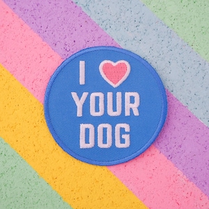 May include: A blue embroidered patch with white text that reads "I love your dog" and a pink heart.
