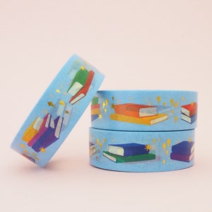 Light blue washi tape printed with small stacks of colourful books and gold-foil sparkles.