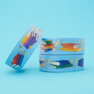 Light blue washi tape printed with small stacks of colourful books and gold-foil sparkles.