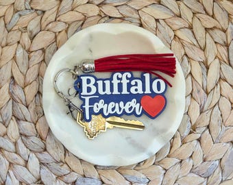 Llavero con la inscripción "Buffalo Forever", dije para bolso azul y rojo. Ideas para regalar en fútbol o hockey.