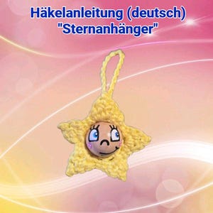 Peut inclure: Ornement en forme d'étoile jaune crochetée avec un visage souriant et une boucle de suspension. Le texte "Häkelanleitung (deutsch) "Sternanhänger"" est en haut. Le fond est un dégradé de rose et de jaune.