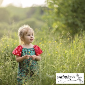 May include: A young girl wearing a teal dress with red polka dot sleeves and a mushroom print stands in a field of green grass and yellow flowers. The dress has a ruffled neckline. The girl is looking off to the side. The text "sewfunky.ca" is visible in the bottom right corner of the image.