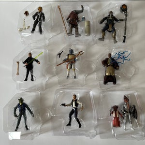 May include: A set of ten Star Wars action figures in plastic packaging. The figures are all different characters from the Star Wars universe, including Luke Skywalker, Darth Vader, and Yoda. The figures are all in their original packaging and are in good condition.