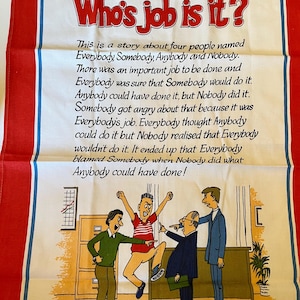 May include: A white tea towel with red borders and the text "Who's job is it?" in red. The towel features a cartoon illustration of four people and a story about responsibility. The text on the towel is in black.