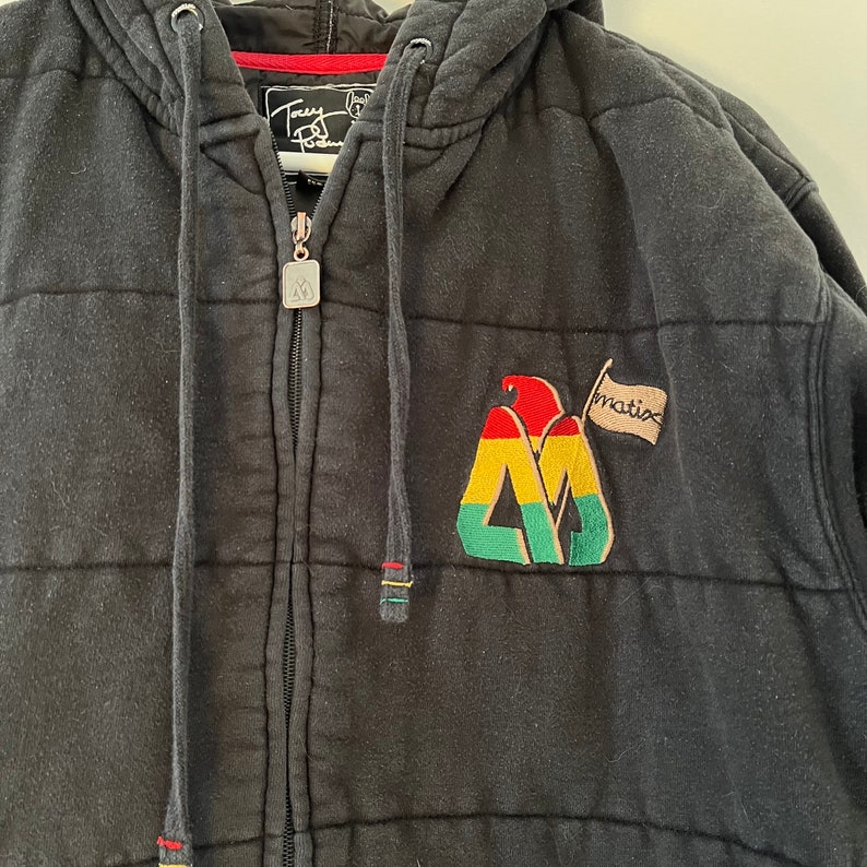 May include: Black quilted zip-up hoodie with a red, yellow, and green logo and the word "Matix" on a white flag.
