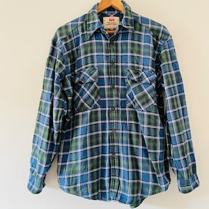 May include: A blue and green plaid long-sleeved button-up shirt with a Levi's label.