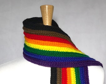 May include: A rainbow striped crocheted scarf with black, brown, red, orange, yellow, green, and purple stripes.
