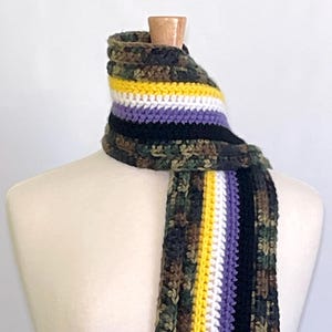 May include: A crocheted scarf with a camouflage pattern and stripes of yellow, white, and purple.
