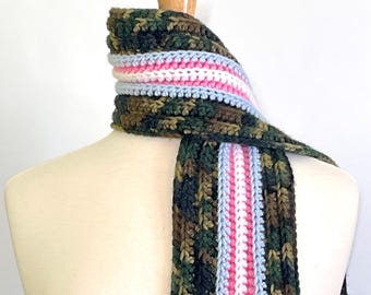 May include: A crocheted scarf with a camouflage pattern and a stripe of pink, white, and blue.