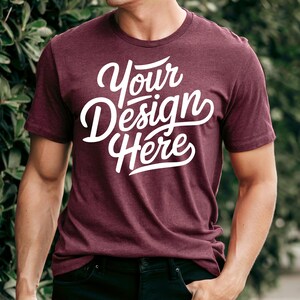 Può includere: Una t-shirt color granata con una grafica bianca che dice "Your Design Here".