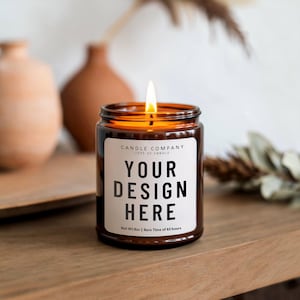 Puede incluir: Un tarro de vela de vidrio marrón con una etiqueta blanca que dice "CANDLE COMPANY TYPE OF CANDLE YOUR DESIGN HERE Net Wt Boz | Burn Time of 40 hours". La vela está encendida y la llama es visible.