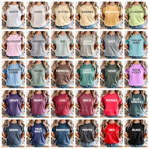 以下が含まれることがあります： さまざまな色の女性用Tシャツのコレクションで、それぞれに白いテキストで色名が付けられています。色は、白、アイボリー、バター、バナナ、マスタード、セラドン、ブロッサム、グラナイト、ベイ、サンドストーン、グレー、チョーキーミント、ウォッシュドデニム、カーキ、エスプレッソ、ライトグリーン、ヘンプ、ネオンバイオレット、グレープ、ベリー、チリ、ブリック、パプリカ、ブルースプルース、デニム、トゥルーネイビー、ミッドナイト、ペッパー、レッド、ブラックなどです。