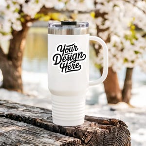 May include: White stainless steel travel mug with a black handle and a sticker that says "Your Design Here".