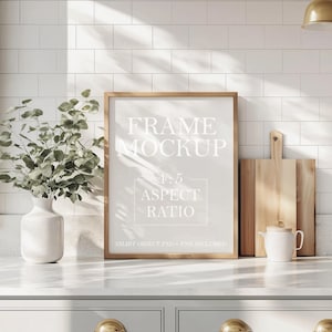 May include: A white frame mockup with the text "FRAME MOCKUP 4:5 ASPECT RATIO SMART OBJECT PSD + PNG INCLUDED" on a white countertop in a kitchen setting.