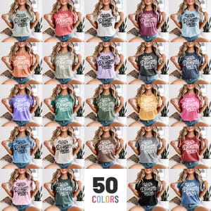 May include: A collection of 50 colorful t-shirts, each featuring the text "Your Design Here" in a script font. The shirts are displayed on models, showcasing a variety of hues, including pastels, neutrals, and vibrant shades. The image highlights the diverse color options available.