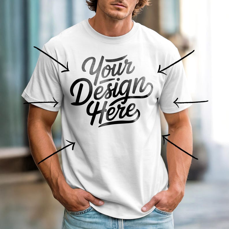 May include: White crew neck t-shirt with the text "Your Design Here" in black script. The shirt is a classic, short-sleeved style, perfect for showcasing custom designs. The model is wearing blue jeans.