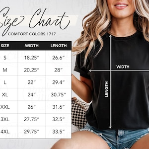 May include: A black t-shirt with a size chart, including measurements in inches, for Comfort Colors 1717. The chart lists sizes S through 4XL, with corresponding width and length measurements. The shirt is being modeled.