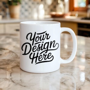 以下が含まれることがあります： 白いセラミックマグカップ、湾曲したハンドル付き。 マグカップには、黒の筆記体フォントで「Your Design Here」というテキストが書かれています。 マグカップは大理石のカウンタートップに置かれています。