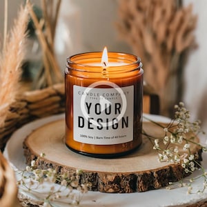 Op de afbeelding: Een bruine glazen kaars met een wit label waarop staat "CANDLE COMPANY TYPE OF CANDLE YOUR DESIGN 100% Soy | Burn Time of 40 hours".