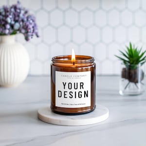 May include: A brown glass candle jar with a white label that says "CANDLE COMPANY TYPE OF CANDLE YOUR DESIGN Net Wt 11oz | Burn Time of 40 hours".