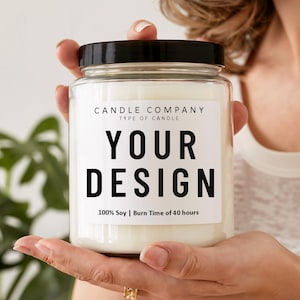 以下が含まれることがあります： 黒い蓋が付いた透明なガラス瓶のキャンドル。キャンドルには、「CANDLE COMPANY」、「TYPE OF CANDLE」、「YOUR DESIGN」というテキストが記載された白いラベルが付いています。ラベルには「100% Soy | Burn Time of 40 hours」とも記載されています。