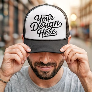 Könnte beinhalten: Eine schwarz-weiße Trucker-Kappe mit Netzrücken. Die Vorderseite der Kappe trägt den Text "Your Design Here" in einer stilisierten Schrift.