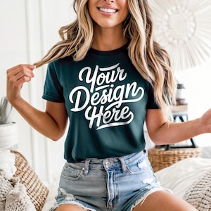 May include: Dark teal t-shirt with the text "Your Design Here" in white script. The shirt has a crew neck and short sleeves. The model is wearing denim shorts.