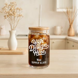 May include: A 16 ounce glass sipper with a bamboo lid and a straw. The glass is filled with iced coffee and has the text "Your Design Here" printed on the side.