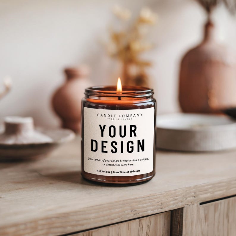 May include: A brown glass candle with a label that says "CANDLE COMPANY" and "YOUR DESIGN". The label also includes the text "Description of your candle & what makes it unique, or describe the scent here" and "Net Wt 8oz | Burn Time of 40 hours".