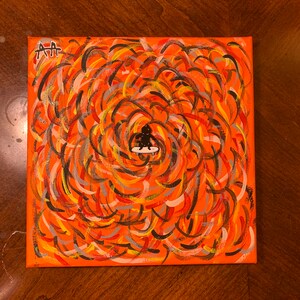 Può includere: Dipinto astratto su tela con una figura nera su uno skateboard al centro. Lo sfondo è un mix vorticoso di vernice arancione, gialla, rossa, nera e grigia.