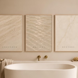 Puede incluir: Tres l&aacute;minas rectangulares en marcos de madera clara con texturas beige y las palabras GROUNDED, BREATHE y RESTORE. La l&aacute;mina de la izquierda muestra piedra, la central ondas de agua y la de la derecha patrones de m&aacute;rmol.