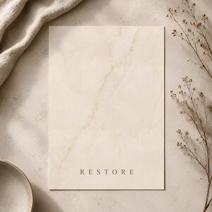 Puede incluir: Una tarjeta rectangular con un patr&oacute;n de m&aacute;rmol color crema que presenta vetas doradas sutiles. La palabra RESTORE est&aacute; impresa en una fuente sans-serif simple y oscura cerca de la parte inferior central de la tarjeta, con acabado mate.