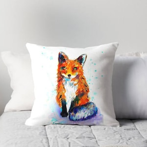 May include: A watercolor painting of a fox sitting on a white background with blue and green splatters of paint. The fox is orange and white with a bushy tail.