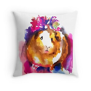 May include: A watercolor painting of a guinea pig wearing a colorful flower crown. The guinea pig is brown and white with a pink nose and is looking directly at the viewer. The background is a watercolor wash of pink, purple, and blue.