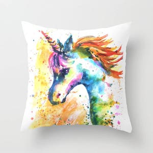 May include: A watercolor painting of a unicorn's head with a rainbow of colors. The unicorn is facing left and has a long, flowing mane and tail. The background is a white canvas with splashes of yellow, orange, and blue paint.