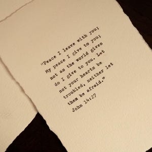 May include: Two pieces of off-white paper with deckled edges featuring black typewriter-style text that reads: "Peace I leave with you; My peace I give to you; not as the world gives do I give to you. Let not your hearts be troubled, neither let them be afraid." John 14:27.