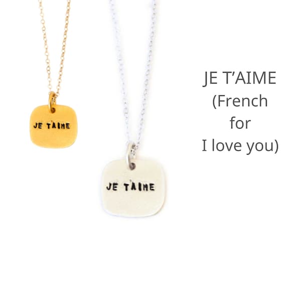 Cita el collar Je T'Aime, francés para "Te amo".  Hecho a mano por Chocolate & Steel, collar estampado a mano de plata reciclada y oro vermeil