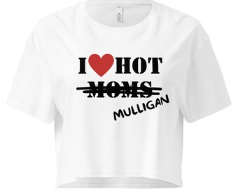 May include: White crop top with the text "I ❤️ HOT MOMS MULLIGAN" in black and red. The word "MOMS" is crossed out with two black lines. The top has a crew neck and short sleeves.