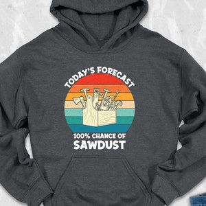 May include: A dark gray hooded sweatshirt with a vintage-style graphic of a toolbox with tools and the text "Today's Forecast 100% Chance of Sawdust".