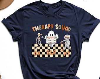 May include: A navy blue t-shirt with the text "Therapy Squad" and a graphic of a skeleton, ghost, and mummy holding a sign that says "OT SLP PT".