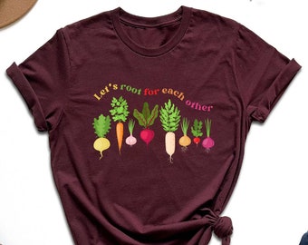 May include: A maroon t-shirt with a graphic of various vegetables and the text "Let's root for each other".
