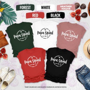 May include: A collection of t-shirts in various colors, including forest green, white, red, heather mauve, and black. Each shirt features the text "Papa Squad" in a circular design. The shirts are displayed with accessories like a hat, shoes, and figs.