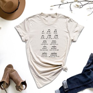 a t - shirt with musical notes on it next to a pair of jeans and