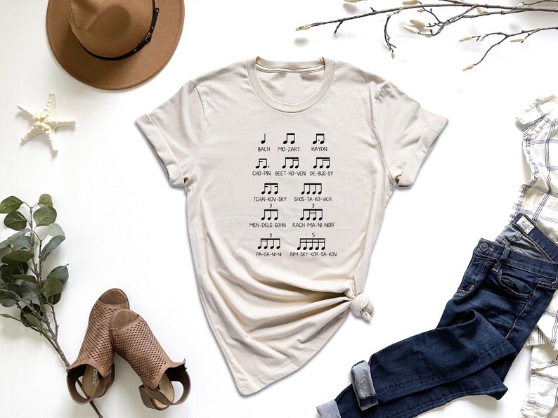 a t - shirt with musical notes on it next to a pair of jeans and