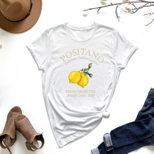a white t - shirt with a lemon on it