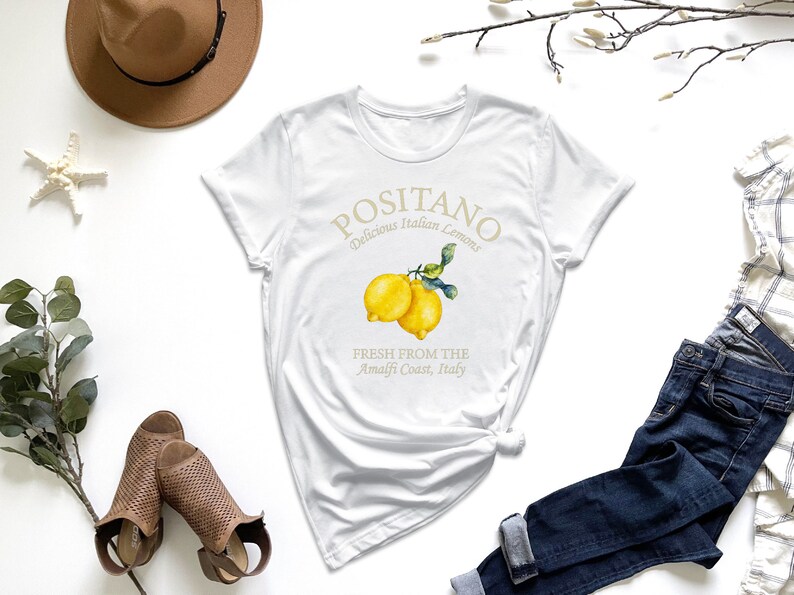a white t - shirt with a lemon on it
