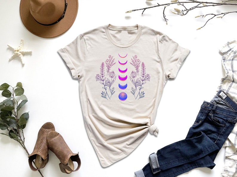 a t - shirt with a design on it next to a pair of jeans and