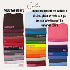 May include: A display of adult sweatshirts in various colors, including dark chocolate, red, and black. The image also features text indicating that some colors are unavailable and to inquire about them. The sweatshirts are neatly stacked.