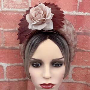 May include: A blush pink and burgundy wide headband with a large blush pink fabric rose and burgundy fabric leaves.