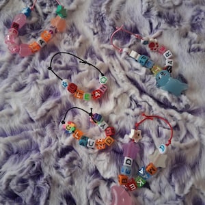 May include: A white ceramic mug with a black handle and the text "But First, Coffee" in a black, bold font. The mug is on a white surface.